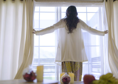 women opening curtains